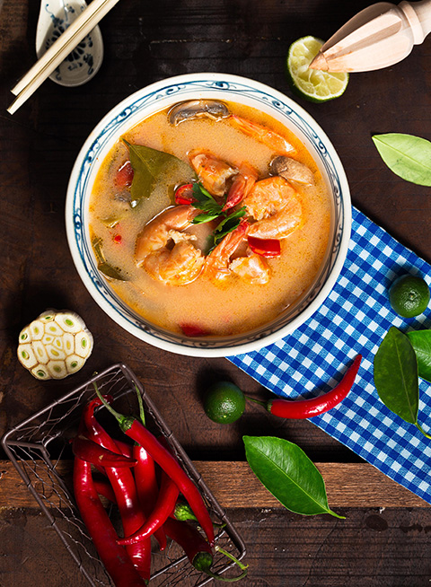 shrimp soup in white ceramic bowl with chili on brown wooden